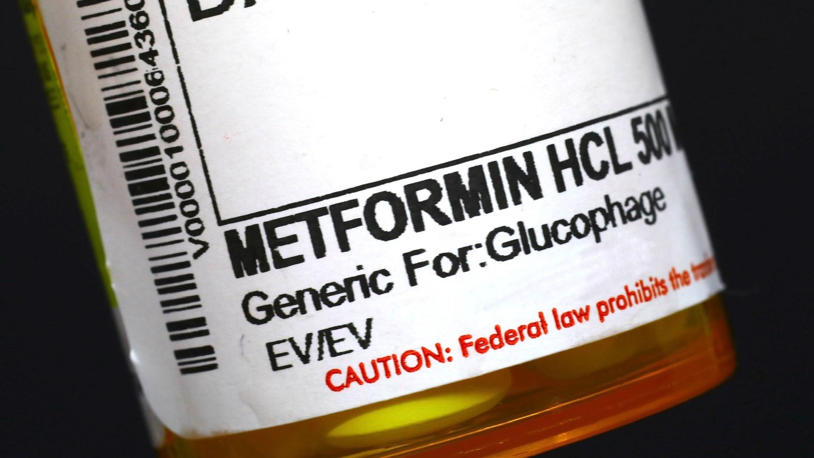 A close up of an orange pill bottle with the label "metformin" on it.