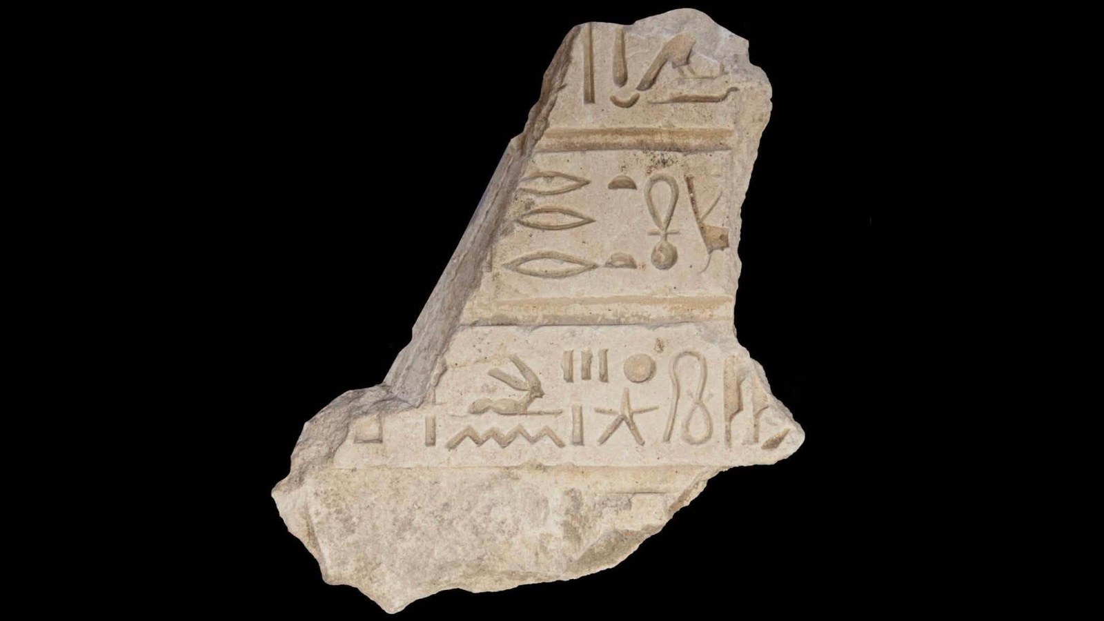 A close up of a stone artifact with writing on it.