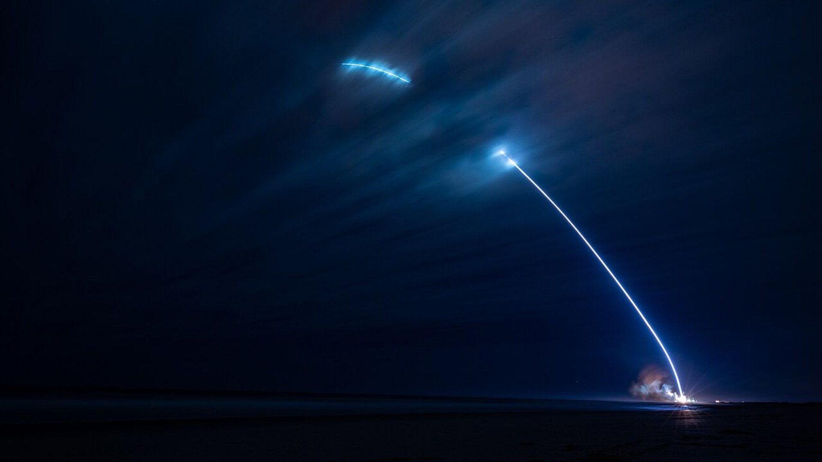 A timelapse photo of the first New Glenn launch showing a streak of light shooting into the night sky