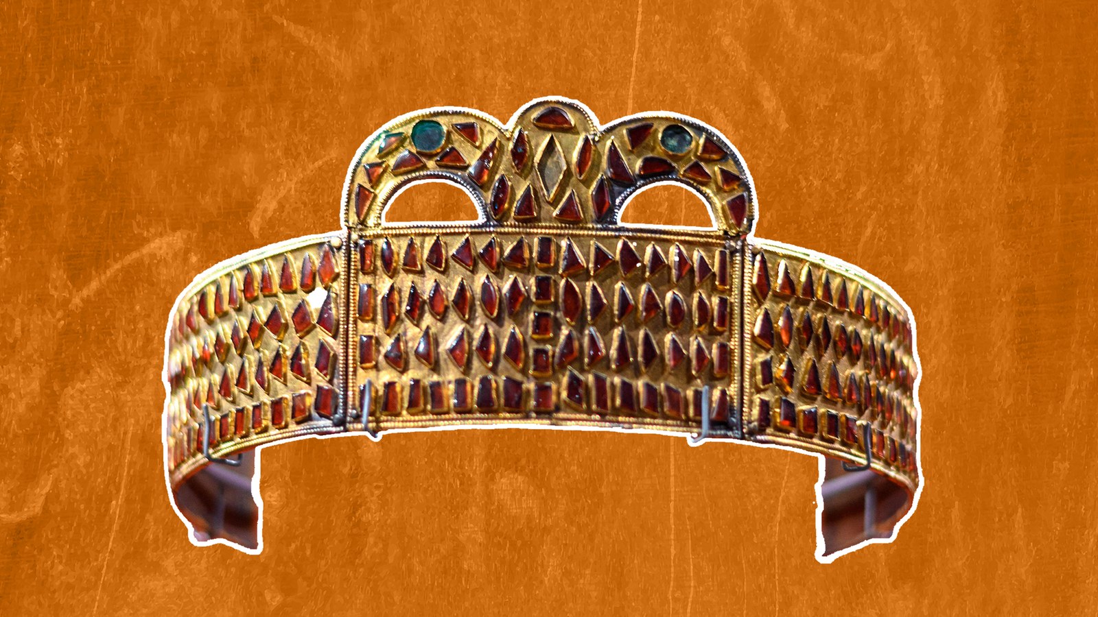 a gold and garnet crown against an orange background