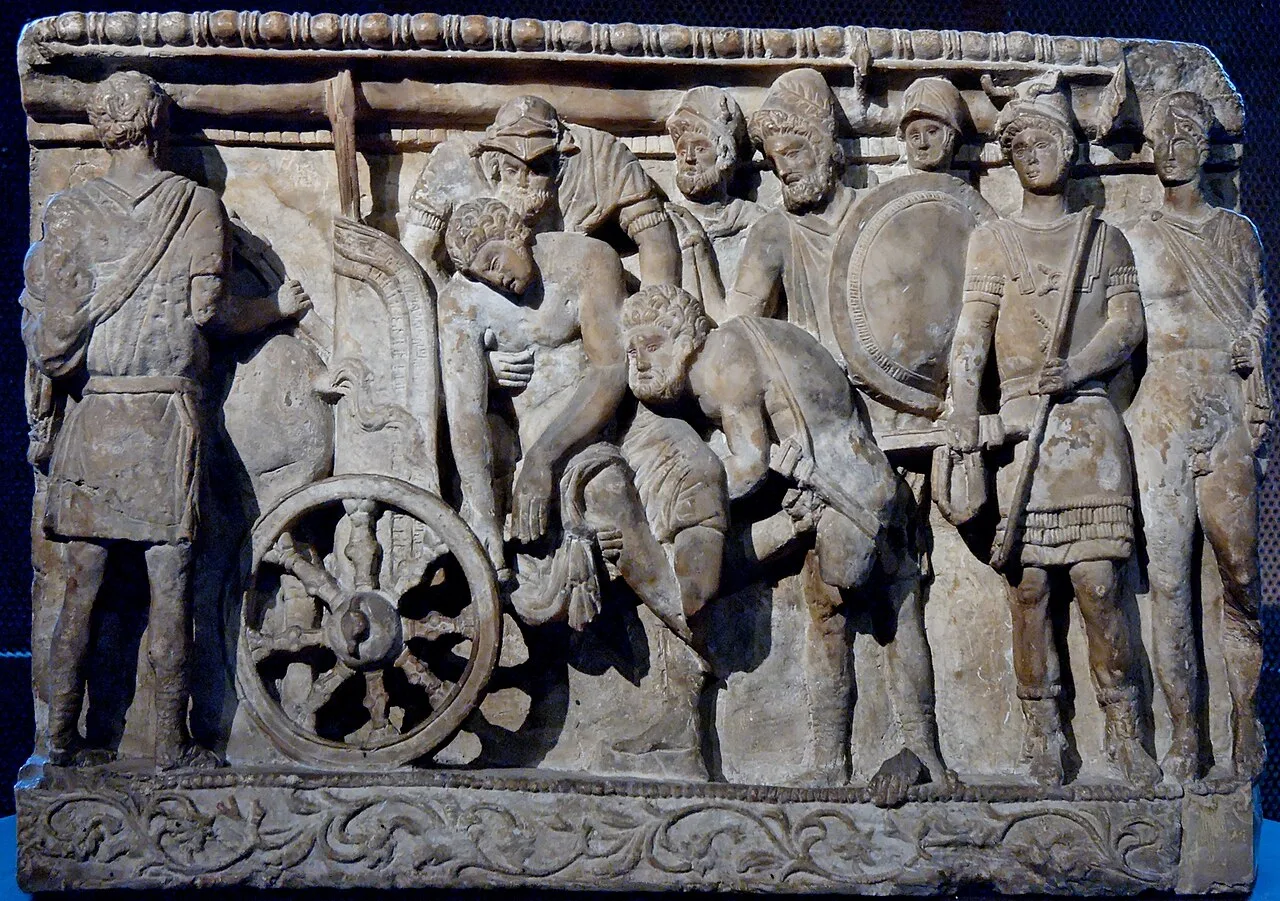 Menelaus and Meriones lifting Patroclus's corpse on a cart while Odysseus looks on, Etruscan alabaster urn from Volterra, Italy, 2nd century BC